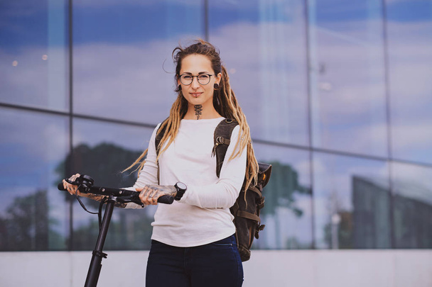 Portrait of young styilish woman with electro scooter - Zdjęcie, obraz