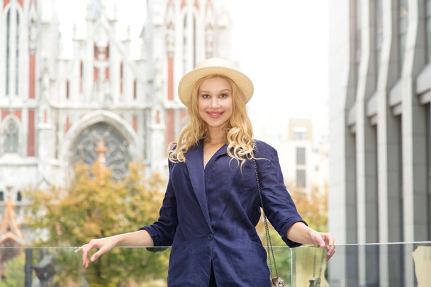 Portrait of a beautiful blonde woman in a hat on a city street background. Europe trip. - Foto, immagini