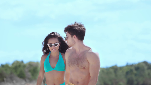 boldog fiatal pár kéz a kézben, és beszél járás közben a tengerparton - Felvétel, videó