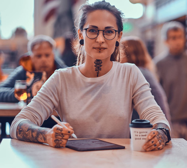 Portrait of beautiful tattoed girl with sketch pad - Φωτογραφία, εικόνα