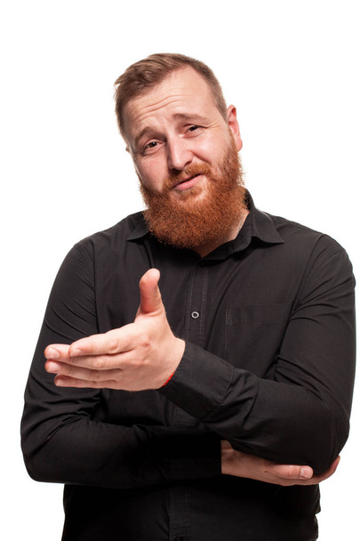 Portrait of a young, chubby, redheaded man in a black shirt making faces at the camera, isolated on a white background - Foto, Imagen