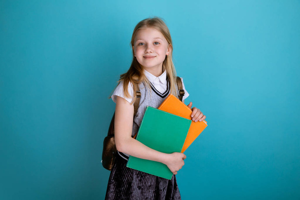 Kız kitap tutan ve okul çantası ile izole ayakta. - Fotoğraf, Görsel