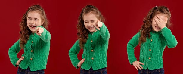 Portrait d'une belle petite fille dans un pull tricoté vert posant sur un fond rouge
. - Photo, image