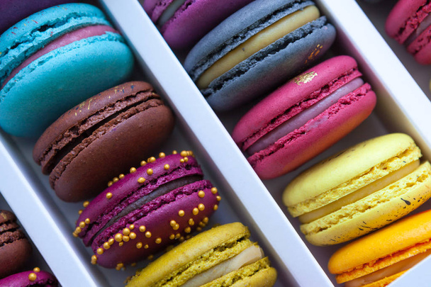 Assortment of multicolored macaroon different lie in the cardboard box with the top view. Close-up - Foto, immagini