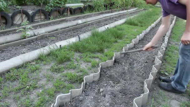 άνθρωπος χαλαρώνει ξηρά Γη στον κήπο - Πλάνα, βίντεο