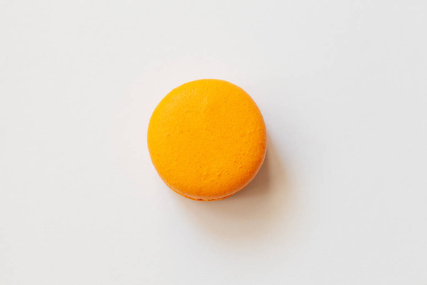 Orange macaroons on a white background, french cookies as a treat for the holiday, top view - Foto, Imagen