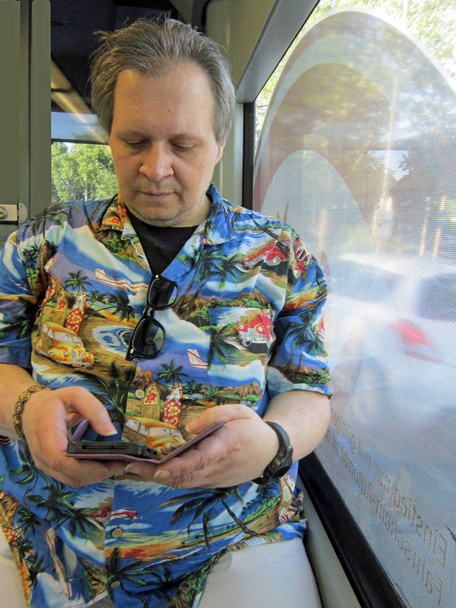 Mann schaut in der Straßenbahn auf sein Smartphone - Foto, Bild
