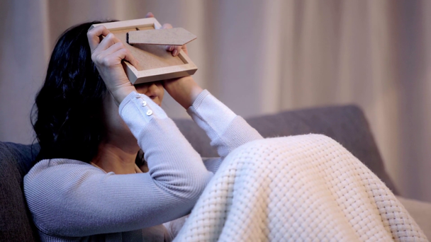 Kobieta patrząc na zdjęcie ramki i płacz w mieszkaniu  - Materiał filmowy, wideo