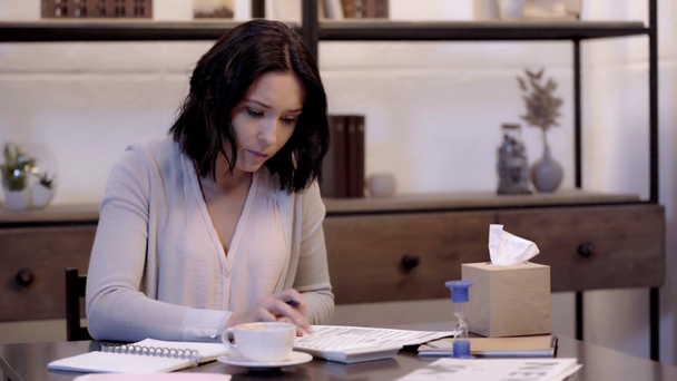 γυναίκα να γράφει σε σημειωματάριο και να κρατά χαρτιά  - Πλάνα, βίντεο