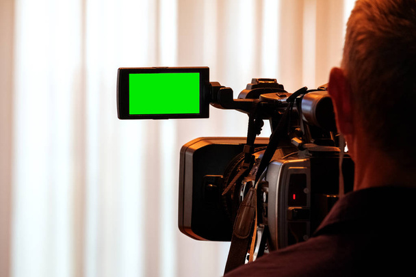 Groen LCD-scherm op high definition TV-camera. Videographer op het werk verwijdert het verhaal voor het nieuws. Sjabloon sjabloon voor het ontwerp van informatie over de TV. - Foto, afbeelding
