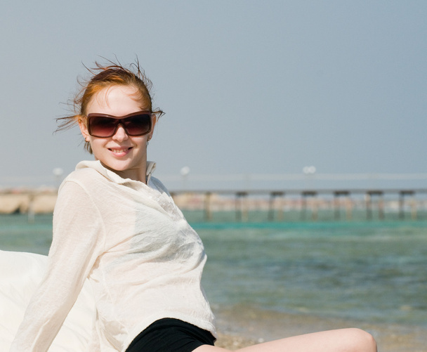Beautiful red woman relaxing by the ocean - Fotografie, Obrázek