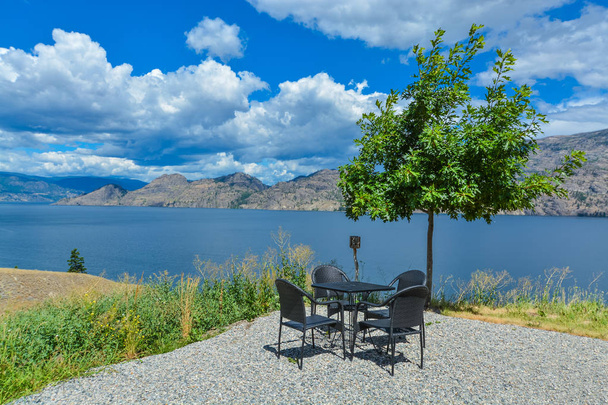 Área de piquenique com mesa de jantar e cadeiras. Vista panorâmica do lago Okanagan
 - Foto, Imagem