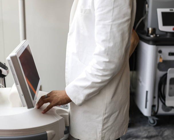 Doctors hands close-up against modern health diagnostic equipment. - Zdjęcie, obraz