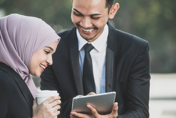 Musulman homme d'affaires et femme d'affaires partenaire discuter en utilisant ta
 - Photo, image