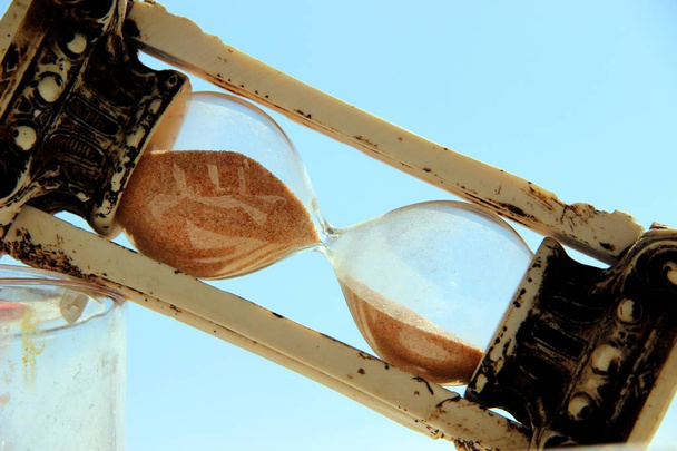 vintage hourglass tilted diagonally against the blue sky - Photo, Image