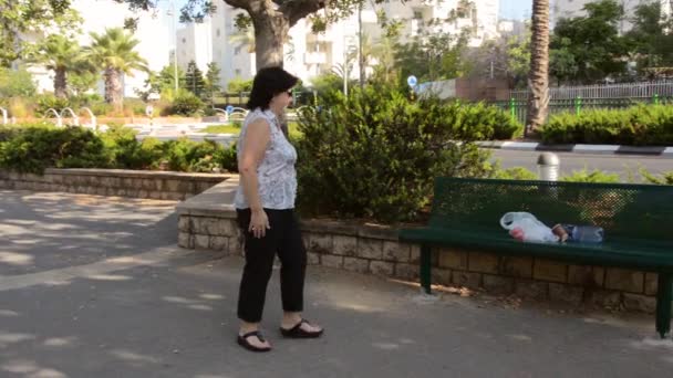 kobieta czyści śmieci pozostawiona przez kogoś - Materiał filmowy, wideo