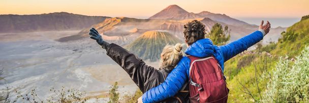 Πανό, Long μορφή νεαρό ζευγάρι άντρας και γυναίκα συναντιούνται την ανατολή του ηλίου στο εθνικό πάρκο Bromo Τένγκερ Τέτσου στο νησί Ιάβα της Ινδονησίας. Απολαμβάνουν μαγευτική θέα στο Bromo ή Gunung Bromo σε - Φωτογραφία, εικόνα