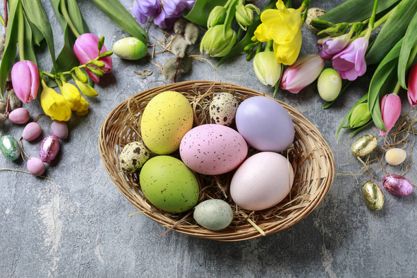 Basket of colorful Easter eggs on grey, stone background.  - 写真・画像