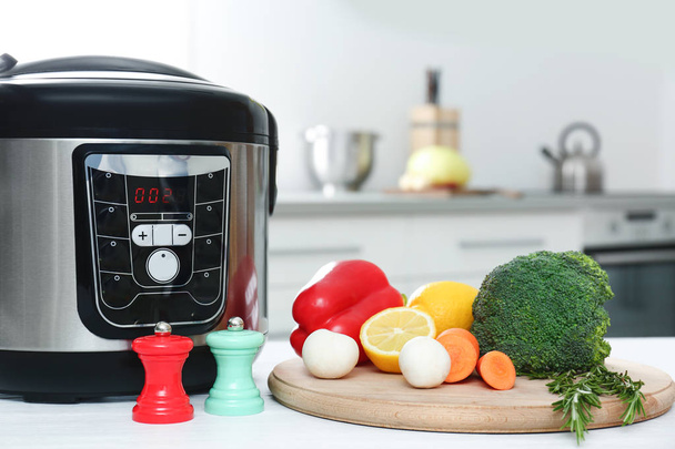 Modern multi cooker and products on kitchen table - Foto, immagini