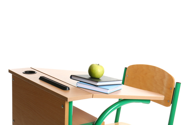 Ξύλινη σχολική επιφάνεια με επιστολόχαρτο και μήλο σε λευκό φόντο - Φωτογραφία, εικόνα