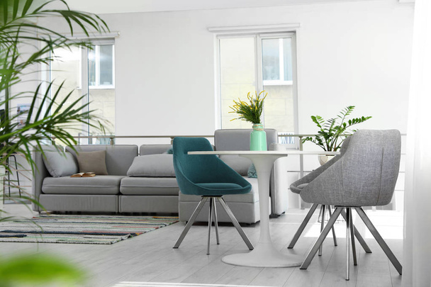Modern living room interior with round table and stylish chairs - 写真・画像