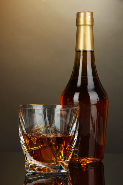 Glass of whiskey with bottle, on dark background - Photo, Image