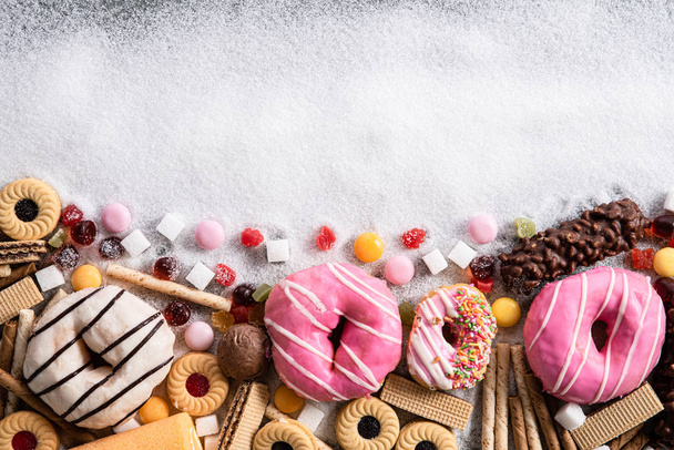 砂糖を含む食品。甘いドーナツ、ケーキ、砂糖の広がりと不健康な栄養、チョコレート乱用と中毒の概念、体と歯科ケアで書かれたテキストのミックス. - 写真・画像