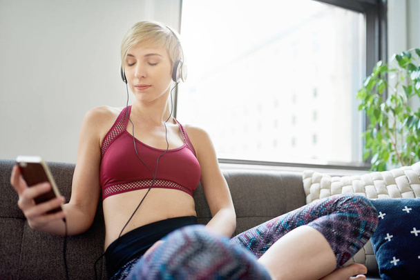 Trendy woman listening to a meditaion app as part of her mindfulness morning routine - Fotoğraf, Görsel