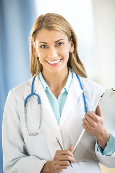 Happy Doctor Holding Clipboard In Clinic - Photo, Image