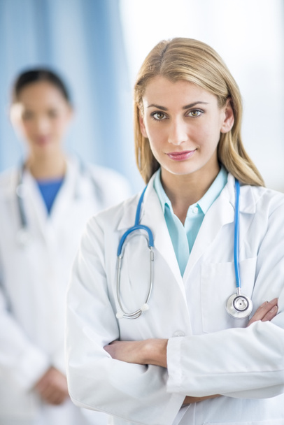 Confident Female Doctor Standing Arms Crossed In Clinic - Foto, Bild