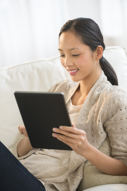 Woman Using Digital Tablet While Relaxing On Sofa - Photo, Image