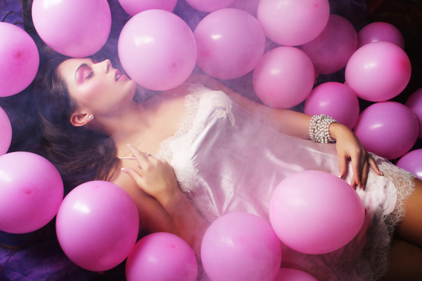 Sleeping woman lying on floor among balloons - Zdjęcie, obraz