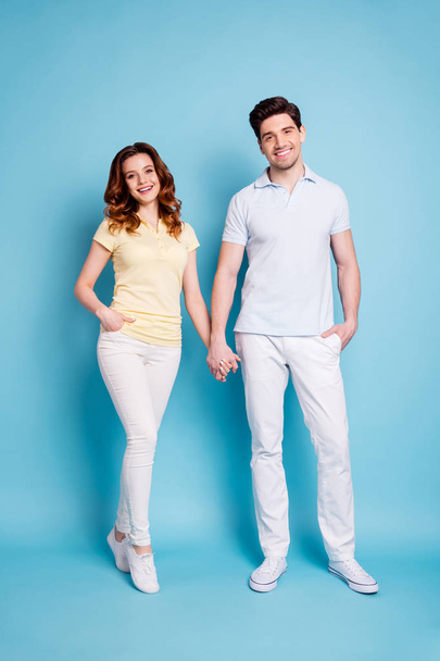 Vertical full length body size view of his he her she nice attractive lovely cheerful cheery married spouses holding hands wearing casual isolated over bright vivid shine blue green background - Zdjęcie, obraz