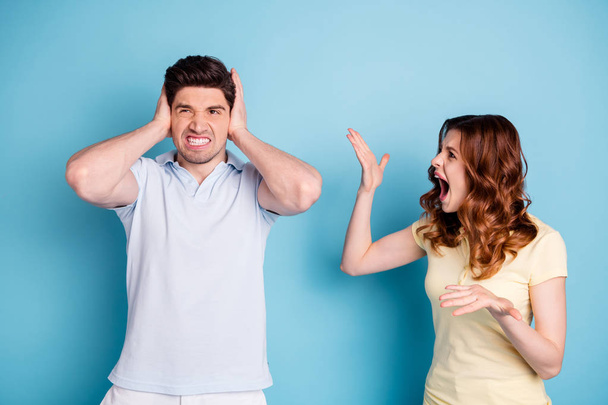 Photo of yelling wife its your fault negative expression husband hiding ears wear casual t-shirts isolated blue background - Foto, Bild