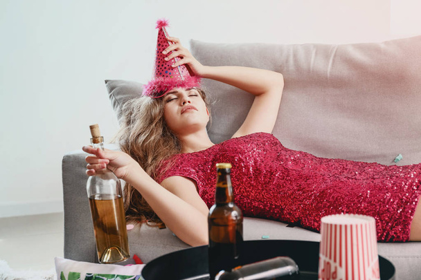 Νεαρή γυναίκα με πονοκέφαλο μετά το πάρτι στο σπίτι - Φωτογραφία, εικόνα