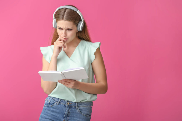 Giovane donna che ascolta musica e lettura libro su sfondo a colori
 - Foto, immagini