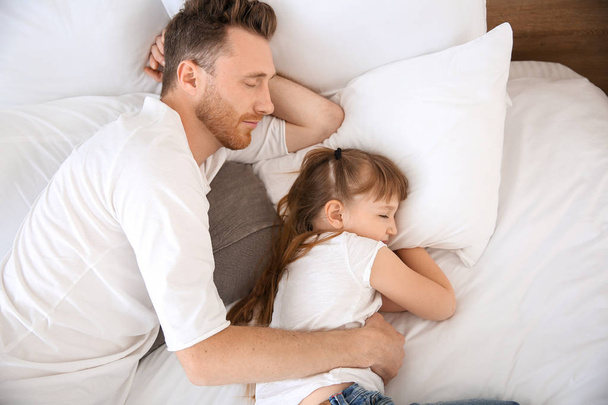 Portrait of happy father and his little daughter sleeping at home - Fotoğraf, Görsel