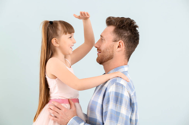 Портрет счастливого отца и его маленькой дочери на цветном фоне
 - Фото, изображение