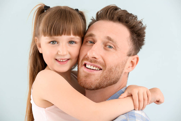 Portrait of happy father and his little daughter on color background - Photo, Image
