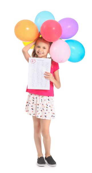 Fille heureuse avec feuille de réponse pour test scolaire et ballons sur fond blanc
 - Photo, image