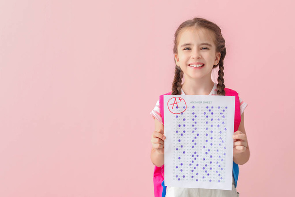 Ragazza felice con foglio di risposta per il test scolastico su sfondo di colore
 - Foto, immagini