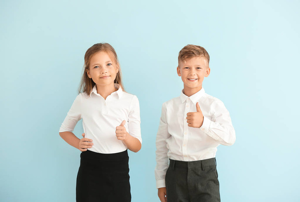Little pupils showing thumb-up on color background - Foto, Imagen