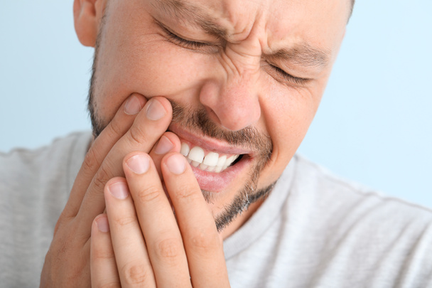 Man suffering from toothache against color background, closeup - Photo, Image