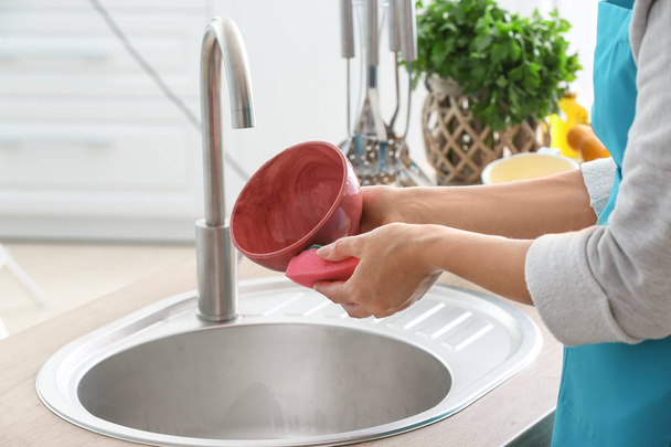 donna che lava i piatti nel lavello della cucina - Foto, immagini