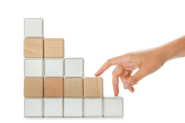 Stacked cubes and female hand imitating walking upstairs against white background. Concept of progress - Photo, Image