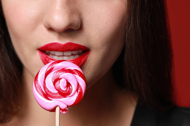 Beautiful young woman with bright lipstick and lollipop, closeup - Φωτογραφία, εικόνα