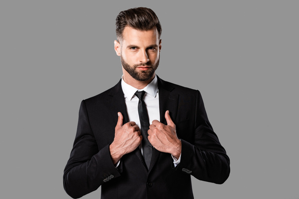 handsome stylish businessman in black suit isolated on grey - Foto, afbeelding