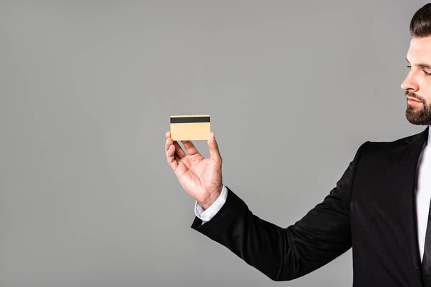 liikemies musta puku osoittaa luottokortin eristetty harmaa
 - Valokuva, kuva