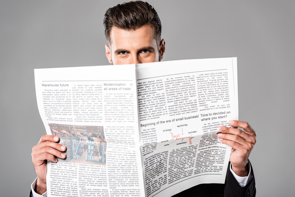 confident businessman in black suit with newspaper isolated on grey - Foto, Imagem