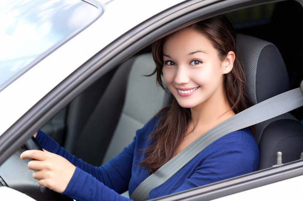 Uuden auton onnellinen omistaja. Kaunis nainen kuljettaja hymyilee sinulle autostaan
 - Valokuva, kuva